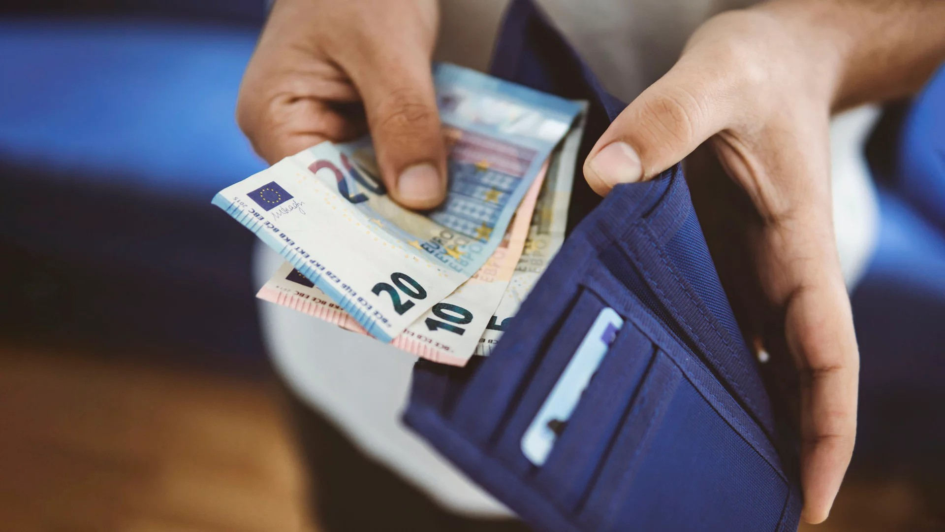 Zwei Hände, Geldbörse und Euroscheine