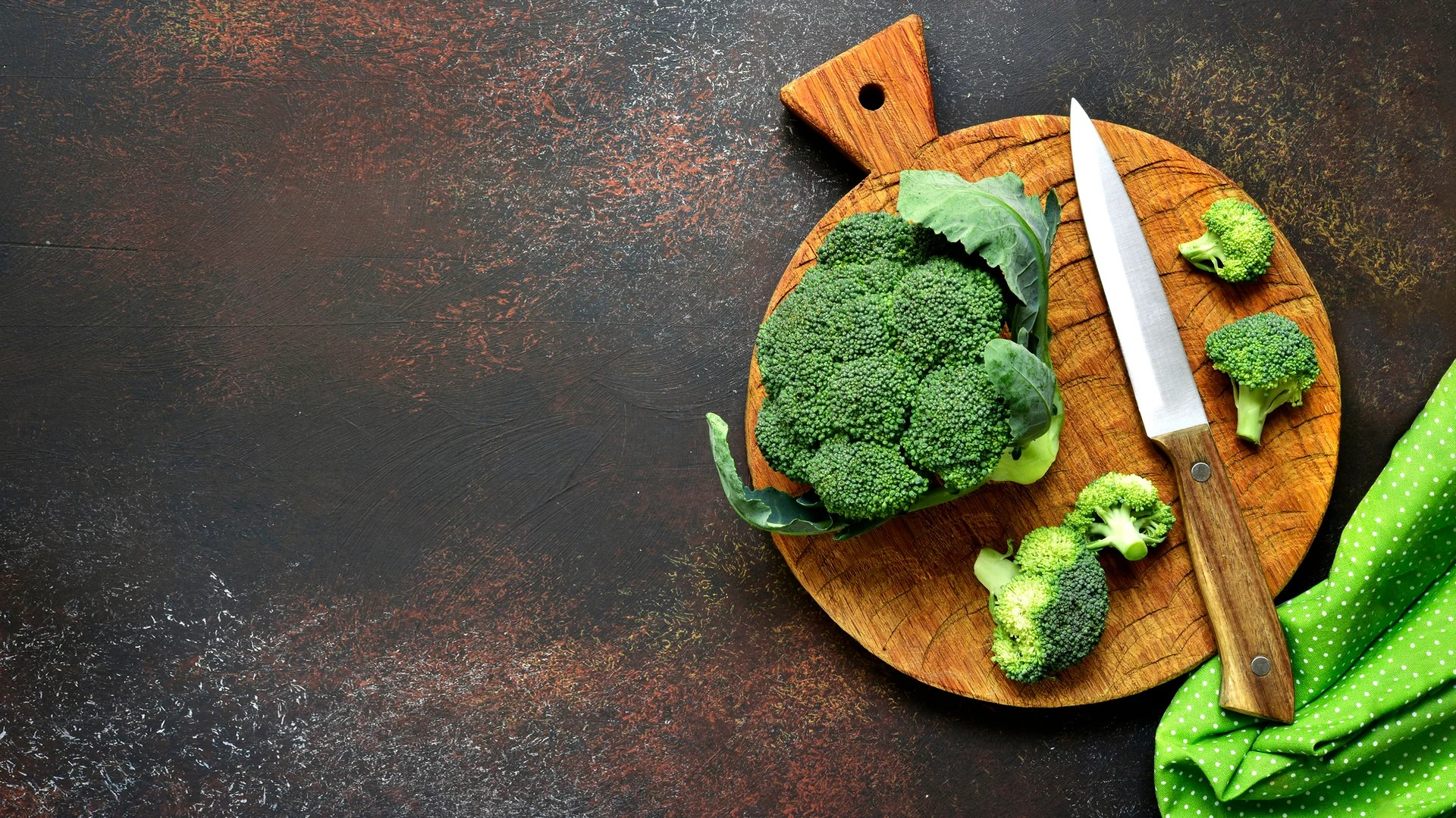 Brokkoli und Messer auf Holzbrettchen